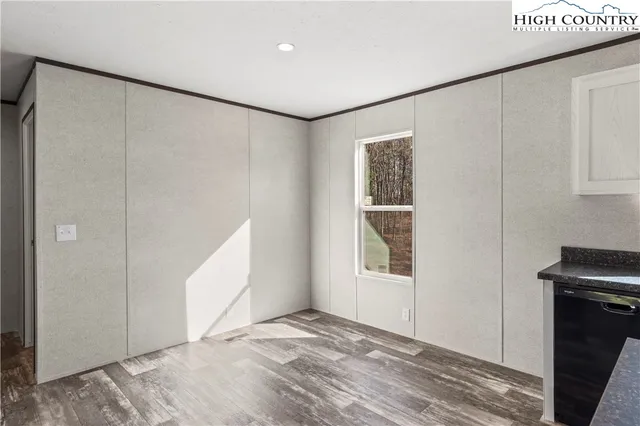 a view of an empty room with window and closet area