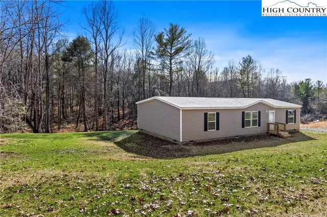 a view of a house with backyard and trees