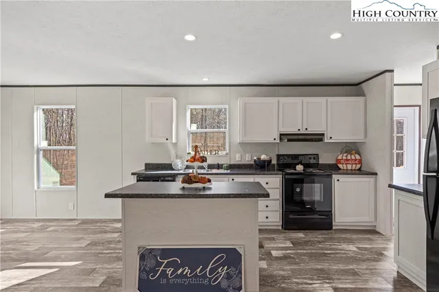 a kitchen with kitchen island granite countertop a stove sink and cabinets