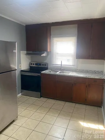 a kitchen with stainless steel appliances granite countertop a sink a stove a refrigerator a counter top and cabinets