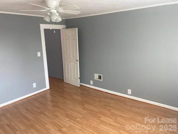 a view of an empty room with wooden floor