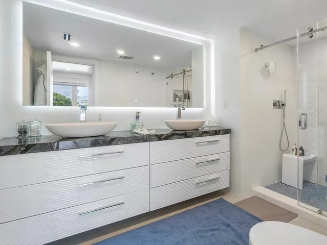 a bathroom with a granite countertop sink toilet and shower
