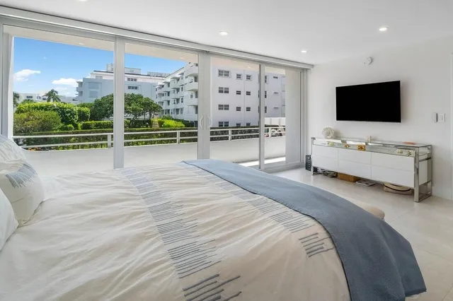 a spacious bedroom with a bed and flat screen tv