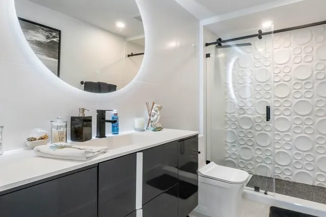 a bathroom with a sink toilet a mirror a vanity and shower