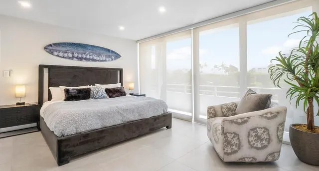 a bedroom with a large bed and a potted plant