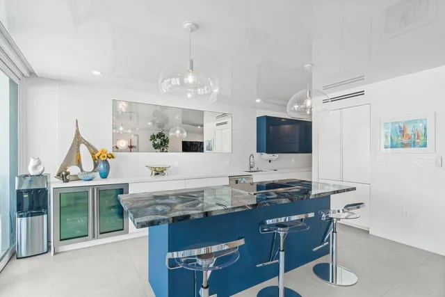 a living room with furniture a flat screen tv and kitchen view