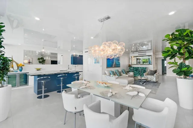 a dining room with furniture a chandelier and kitchen view