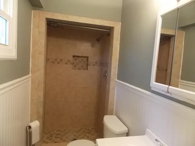 a bathroom with a toilet and a shower