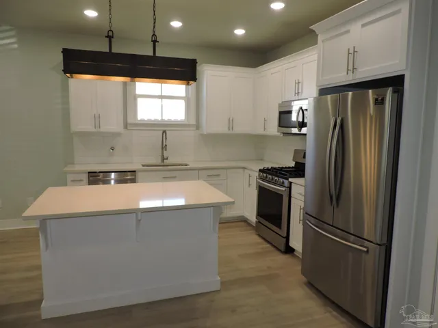 a kitchen with stainless steel appliances a refrigerator and a stove top oven