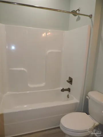 a bathroom with a toilet and a bath tub