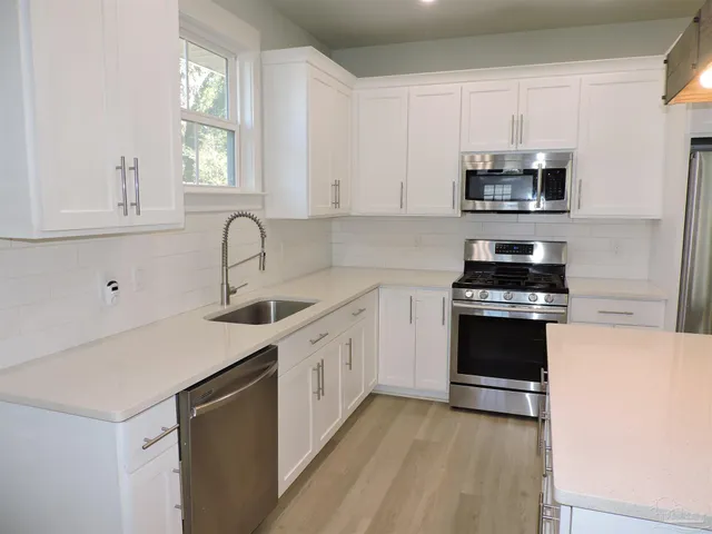a kitchen with stainless steel appliances a sink stove and microwave