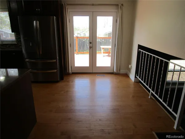 a view of a hallway with wooden floor and stairs