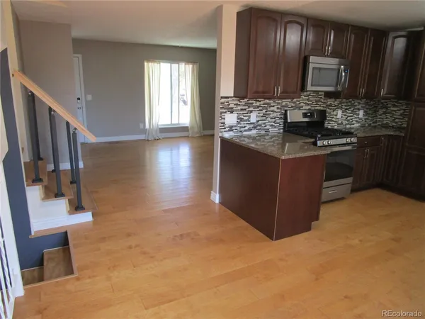a kitchen with stainless steel appliances granite countertop a stove a sink and a microwave