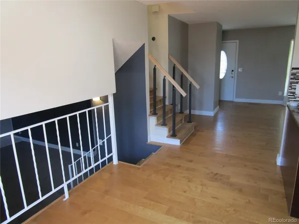 a view of a hallway with wooden floor and stairs