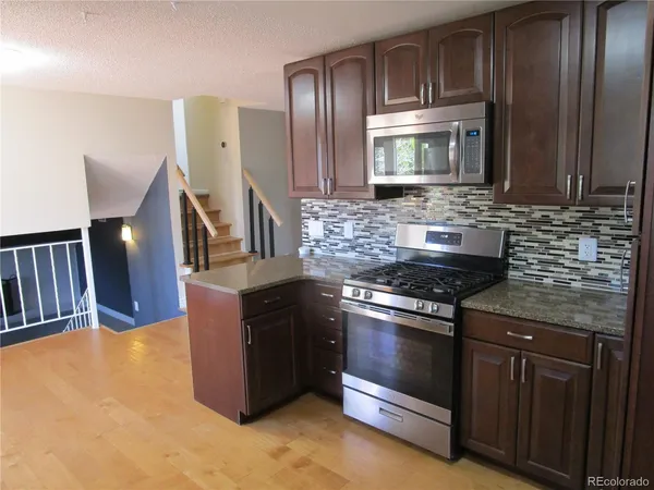 a kitchen with stainless steel appliances granite countertop a stove and a microwave