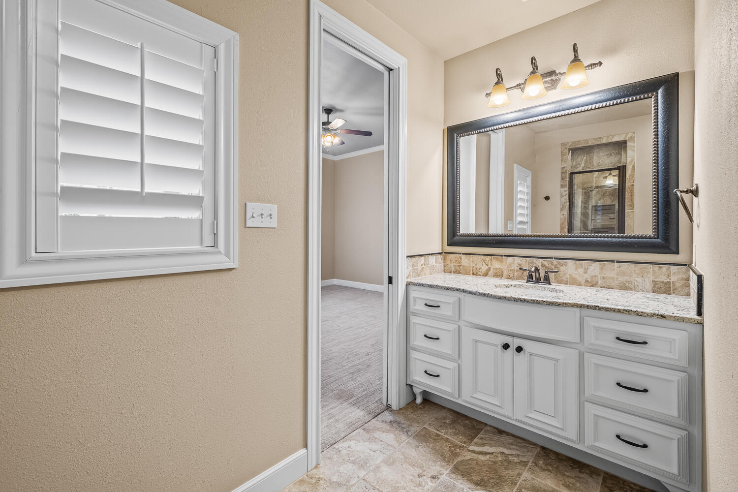 4509 103rd Street Lubbock, TX 79424 - Photo 43 of 94 a bathroom with a granite countertop sink and a mirror