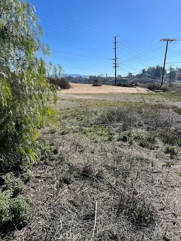 a view of a dry yard with wooden fence