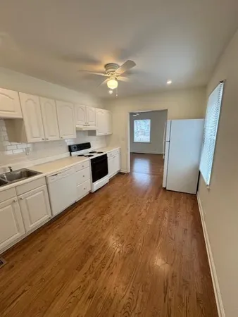a view of a kitchen with wooden floor and a sink