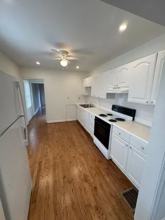a kitchen with granite countertop a stove top oven a sink dishwasher and a refrigerator with wooden floor