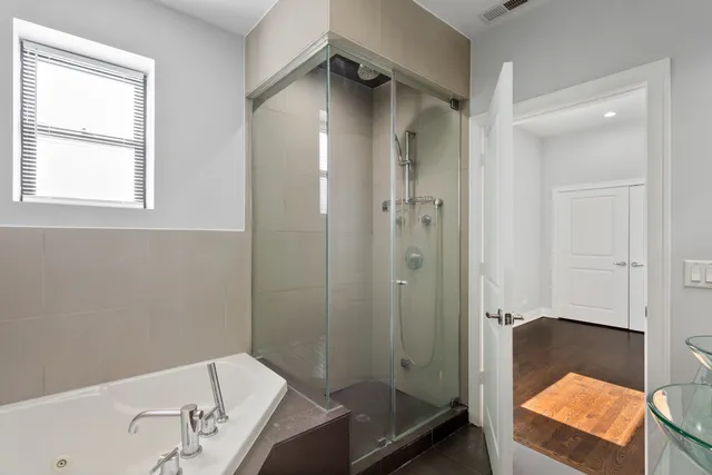 a bathroom with a tub shower and sink