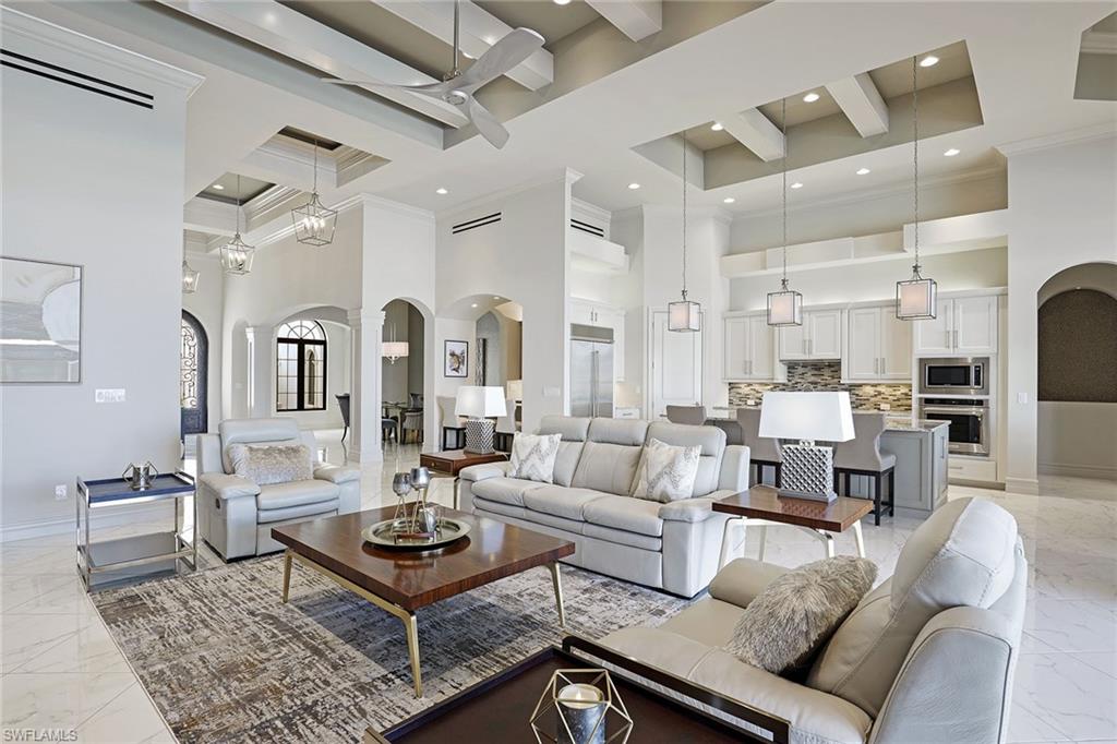 16459 Seneca Way Naples, FL 34110 - Photo 13 of 50 a living room with furniture a rug and a chandelier
