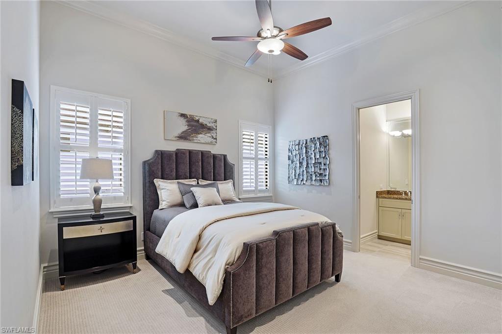 16459 Seneca Way Naples, FL 34110 - Photo 23 of 50 a bedroom with a bed and a chandelier