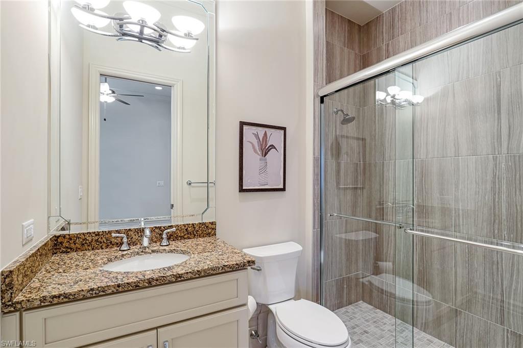 16459 Seneca Way Naples, FL 34110 - Photo 24 of 50 a bathroom with a granite countertop sink toilet and shower
