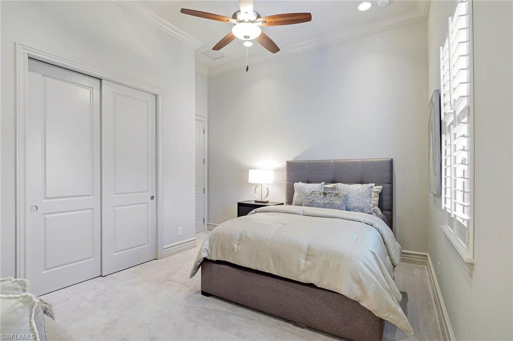 16459 Seneca Way Naples, FL 34110 - Photo 25 of 50 a bedroom with a bed and a chandelier