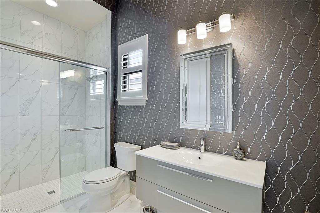 16459 Seneca Way Naples, FL 34110 - Photo 32 of 50 a bathroom with a sink mirror toilet and shower