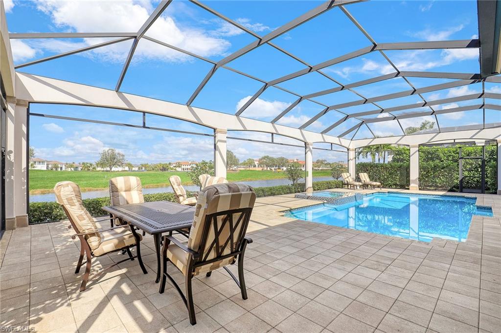 16459 Seneca Way Naples, FL 34110 - Photo 37 of 50 a view of a patio with a table and chairs under an umbrella