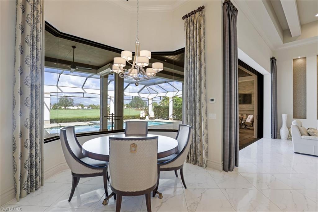 16459 Seneca Way Naples, FL 34110 - Photo 4 of 50 a view of a dining room with furniture wooden floor and chandelier