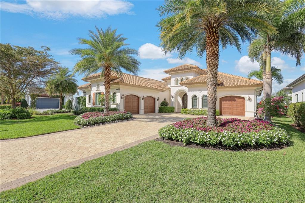 16459 Seneca Way Naples, FL 34110 - Photo 43 of 50 a front view of a house with a garden and trees