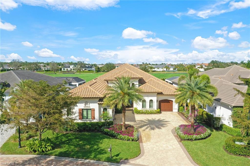 16459 Seneca Way Naples, FL 34110 - Photo 44 of 50 a view of a white house with a big yard and potted plants