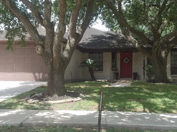 a view of a yard in front of a house with large tree