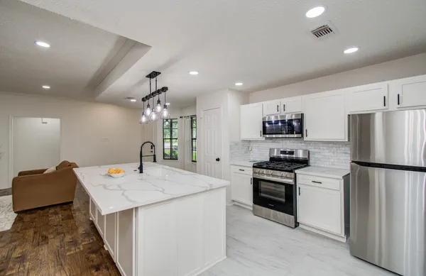 a kitchen that has a lot of cabinets a sink and a stove in it