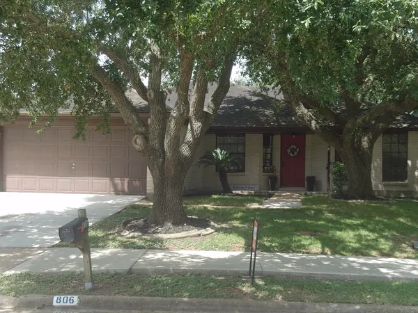 a view of a yard in front of a house with large tree