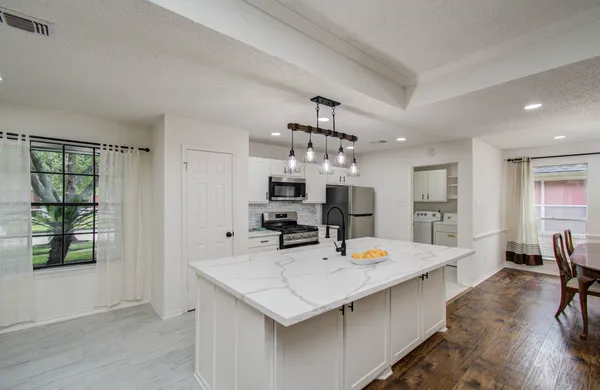 a large kitchen with a table and chairs