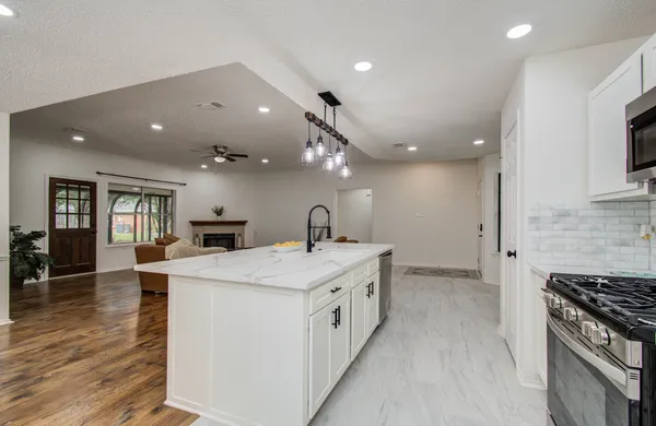 a large white kitchen with stainless steel appliances