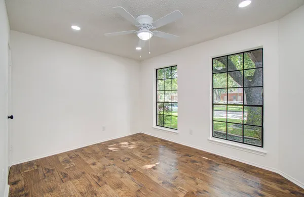 a view of a big room with windows and chandelier fan