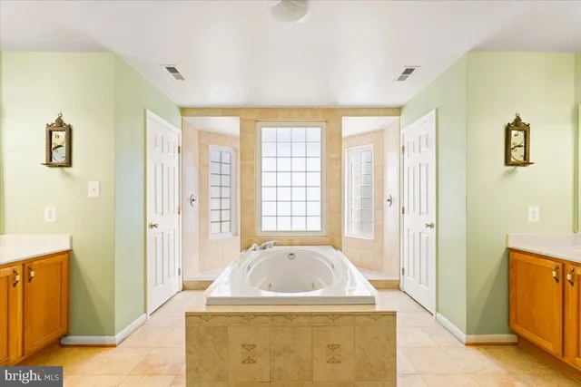 a white bath tub sitting in a bathroom next to a window
