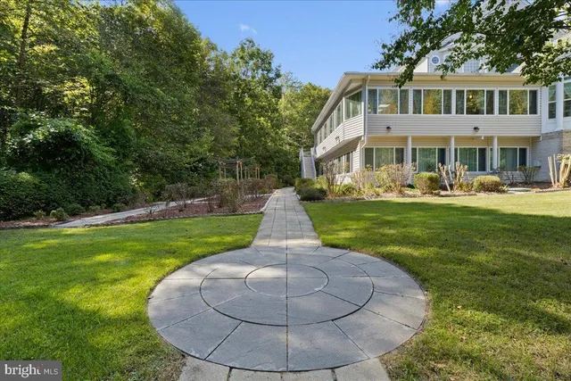 a view of a room with wooden floor fireplace and windows