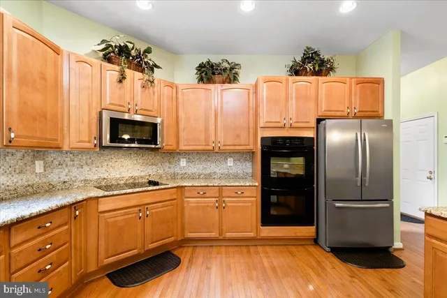 a kitchen with kitchen island granite countertop a sink a counter top space and cabinets