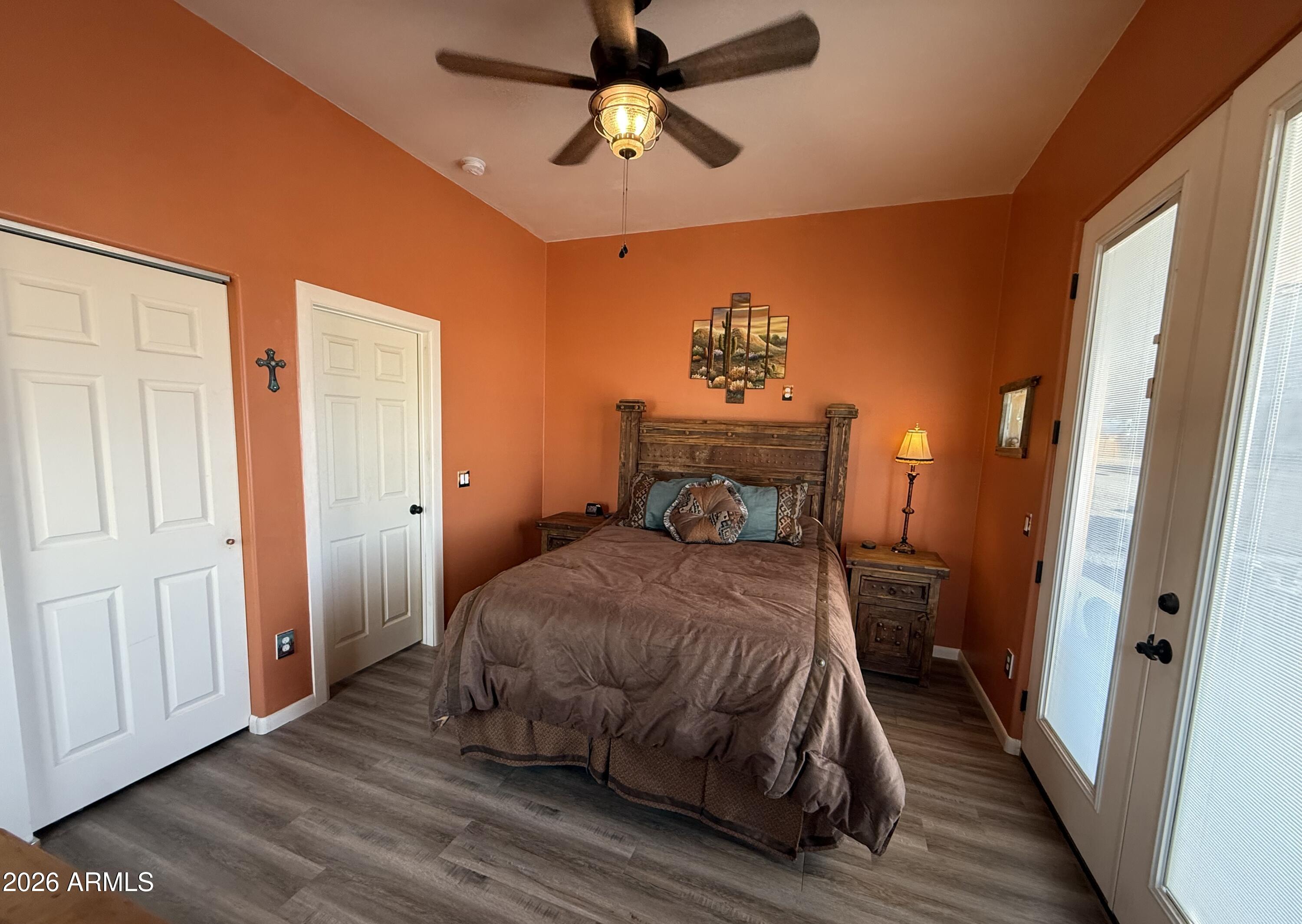 10545 North Ralston Road Maricopa, AZ 85139 - Photo 13 of 27 a bedroom with a bed and wooden floor