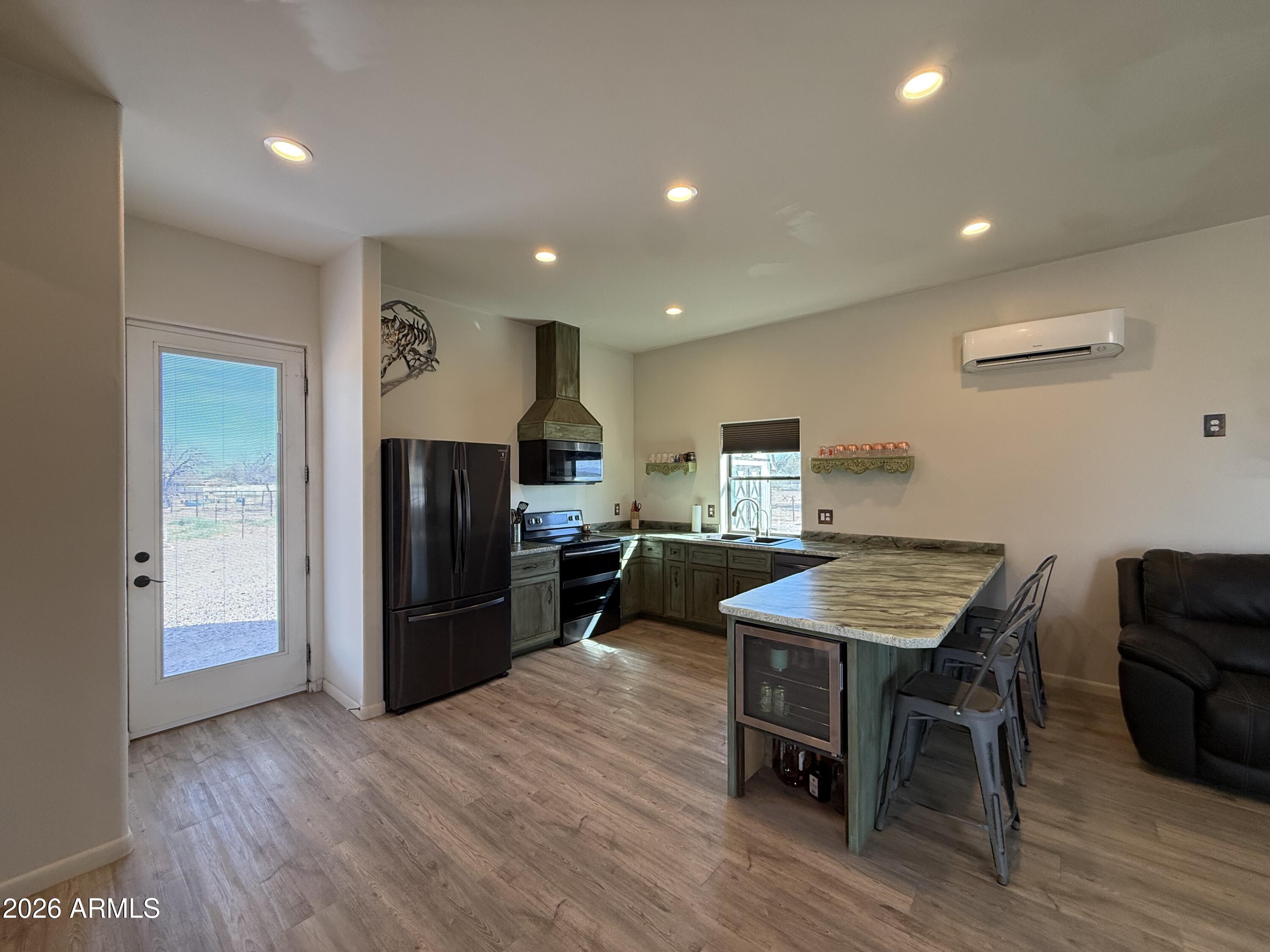 10545 North Ralston Road Maricopa, AZ 85139 - Photo 3 of 27 a kitchen with stainless steel appliances wooden floor and chairs