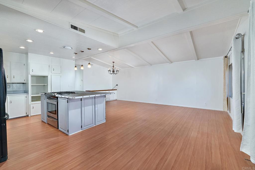 1195 La Moree Road, Unit SPC 42 San Marcos, CA 92078 - Photo 12 of 52 a large kitchen with stainless steel appliances a large counter top a stove and a wooden floors