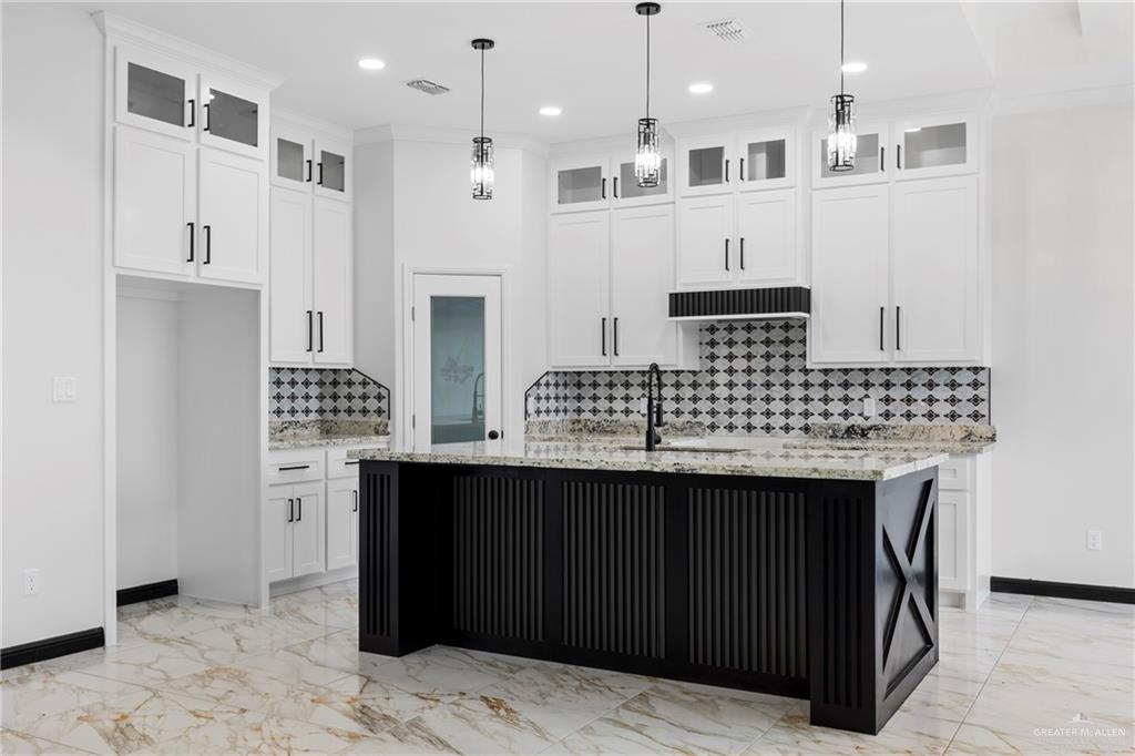 7 John Street Rio Grande City, TX 78582 - Photo 4 of 17 a kitchen with kitchen island granite countertop a sink cabinets and stainless steel appliances