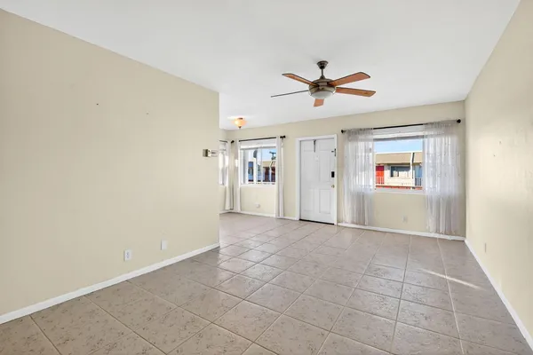 a view of a livingroom with a chandelier fan and windows