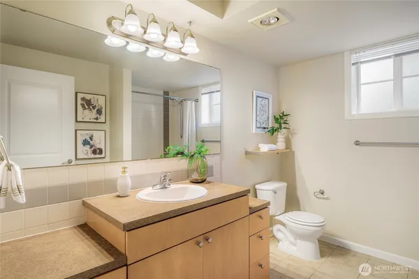 a bathroom with a sink vanity mirror and toilet