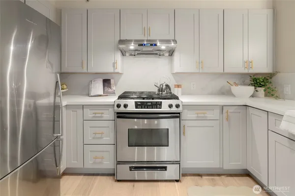 a kitchen with stainless steel appliances granite countertop a stove and a refrigerator