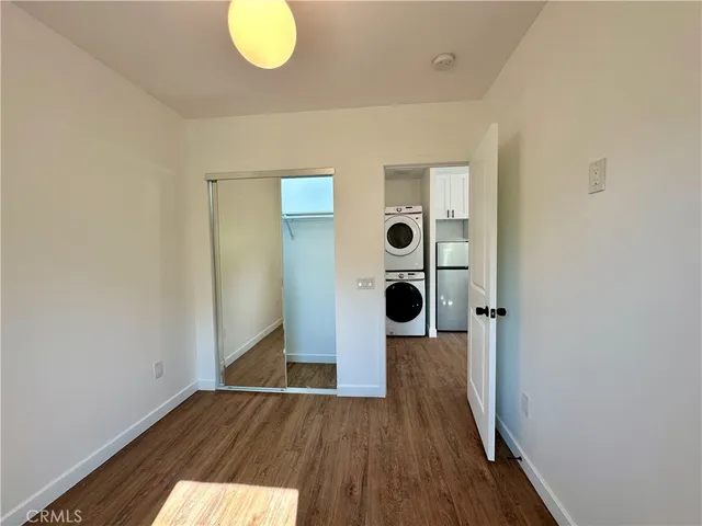 an empty room with wooden floor and mirror
